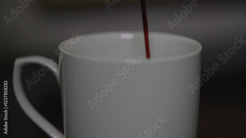 slow motion video of coffee decoction and milk mixes in a white cup