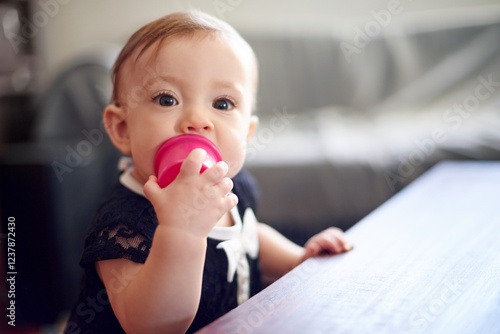 Obraz na plátne Biting, teething and toy with baby at table in home for child development, coordination or growth