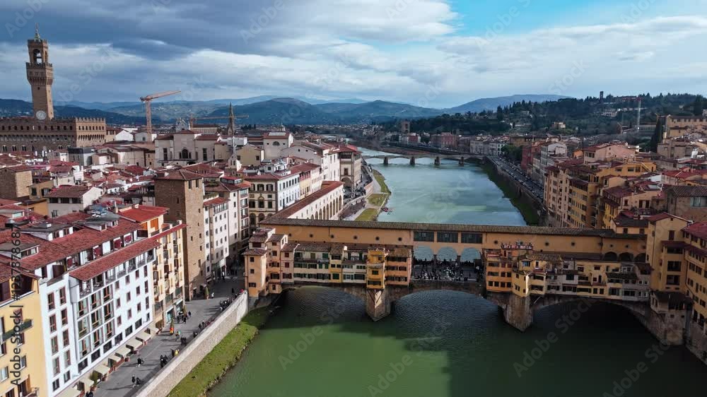 Historic Ponte Vecchio bridge in Florence, Italy, with the Arno River and cityscape Historic Ponte Vecchio bridge in Florence, Italy, with the Arno River and cityscape