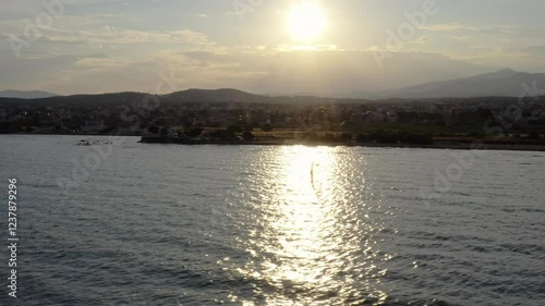 Windsurfing under the sun beam on a sunny day