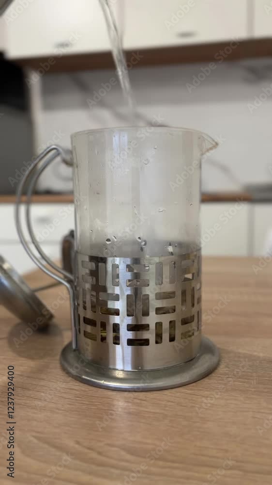 boiling water in the kitchen is poured into a teapot boiling water in the kitchen is poured into a teapot