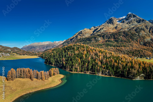 Scenic view of Lake Champfer amidst Piz Surlej mountain under clear blue sky photo