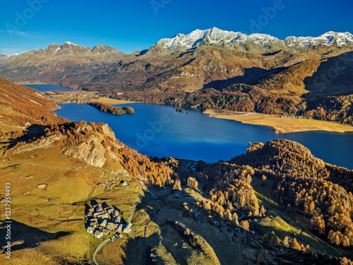 Drone view of Lake Sils amidst Grevasalvas mountain in Switzerland under clear blue sky photo