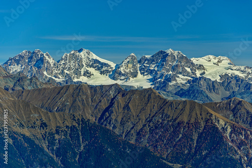 Drone view of Bergamasque Alps during winter under blue sky in Italy photo