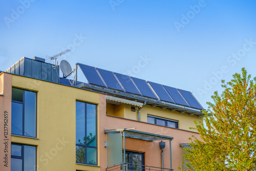 Solar panels installed on roof of house under clear sky photo