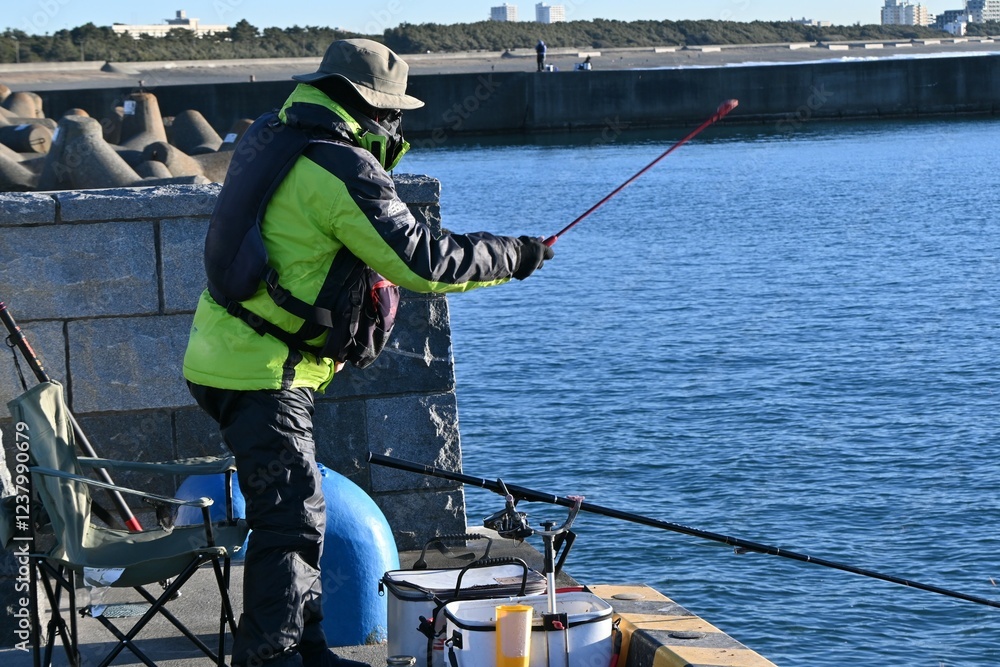 Obraz premium A scene of anglers on the embankment of a fishing port. Background material for holiday hobbies.