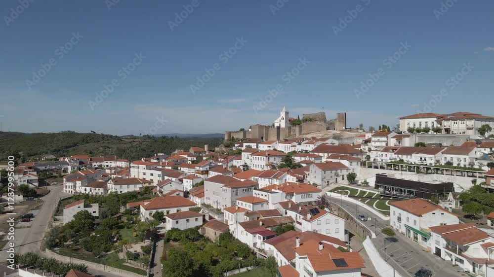Aerial view of Penela a 1137 municipality of Portugal. Drone slowly moving forward and to the left over the rooftops of the municipality in the direction of the castle fortifications and the blue sky. Aerial view of Penela a 1137 municipality of Portugal. Drone slowly moving forward and to the left over the rooftops of the municipality in the direction of the castle fortifications and the blue sky.