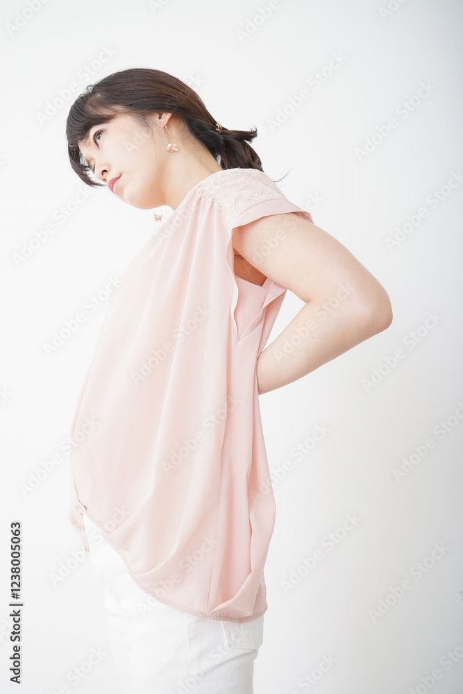 腰の痛みを感じる若い女性 腰の痛みを感じる若い女性