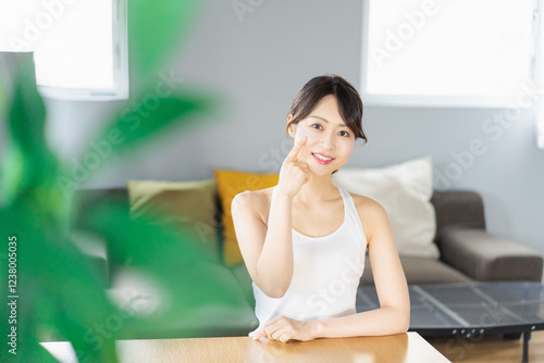 部屋でスキンケアをする若い女性 photo