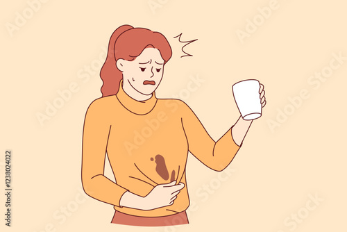 Clumsy woman spills coffee on sweater and needs urgent washing to prevent stain from drying. Clumsy girl makes unhappy grimace due to pain caused by spilled hot drink from white mug