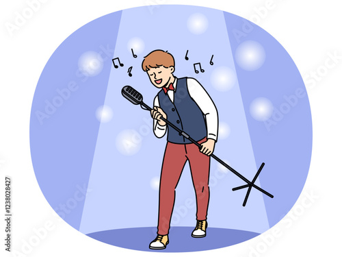 Talented boy singer holds professional microphone on tripod and performs at concert standing in light of spotlight. Happy teenage child singer dreams of becoming star and touring world