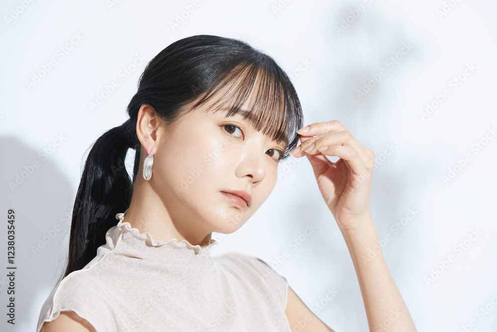 Obraz premium 光と影の背景で撮影をした若い女性の爽やかなビューティーポートレート