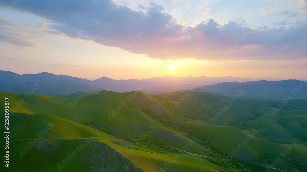 Aerial view of green hills and cloudy sky at sunset in spring, panoramic landscape from a drone with summer nature, sunlight on the grassy mountains Aerial view of green hills and cloudy sky at sunset in spring, panoramic landscape from a drone with summer nature, sunlight on the grassy mountains