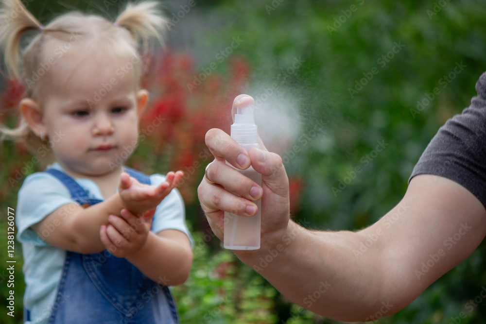 mother applies an aerosol insect spray to the child's body. Selective focus mother applies an aerosol insect spray to the child's body. Selective focus