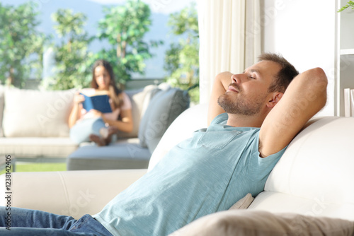 Free Download Man relaxing at home and his girlfriend reading a book in terrace - GFXLoad
