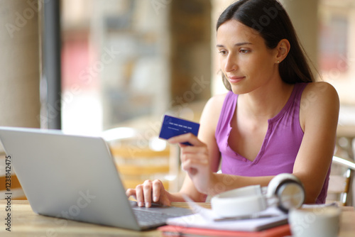 Student buying online in a bar terrace photo