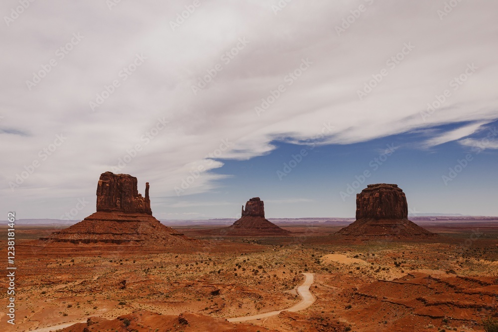 Scenic view of Monument Valley's iconic buttes under a partly cloudy sky, showcasing the vast desert Scenic view of Monument Valley's iconic buttes under a partly cloudy sky, showcasing the vast desert