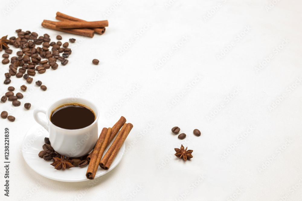 Cup of coffee, cinnamon sticks and star anise on saucer