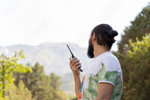Valokuva Faceless man holding two-way radio for hiking