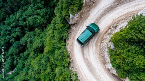 Wallpaper Mural Aerial view of a green vehicle navigating a winding dirt road through lush forest. Torontodigital.ca