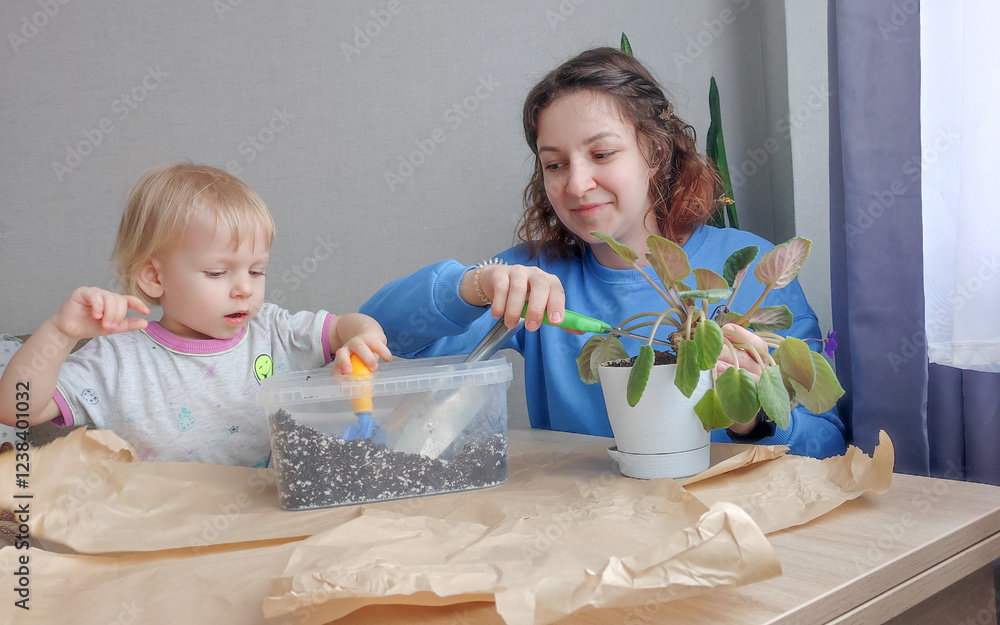 young mother with her little child are replanting houseplants. Toddler development and time together with a child on maternity leave, self-development and mental health