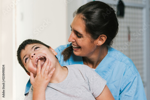 Physiotherapist assisting a child with cerebral palsy smiling and having fun