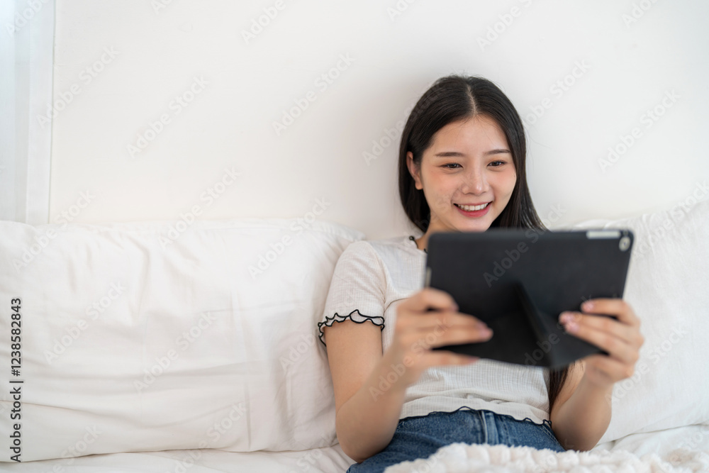 Portrait of smiling happy asian woman relax using digital tablet.Young asian girl working or study,chatting social network and playing game online or social media,shopping online Portrait of smiling happy asian woman relax using digital tablet.Young asian girl working or study,chatting social network and playing game online or social media,shopping online