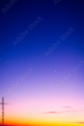 crescent moon and venus in the sky. yellow, purple and blue sky. dramatic sunset photo