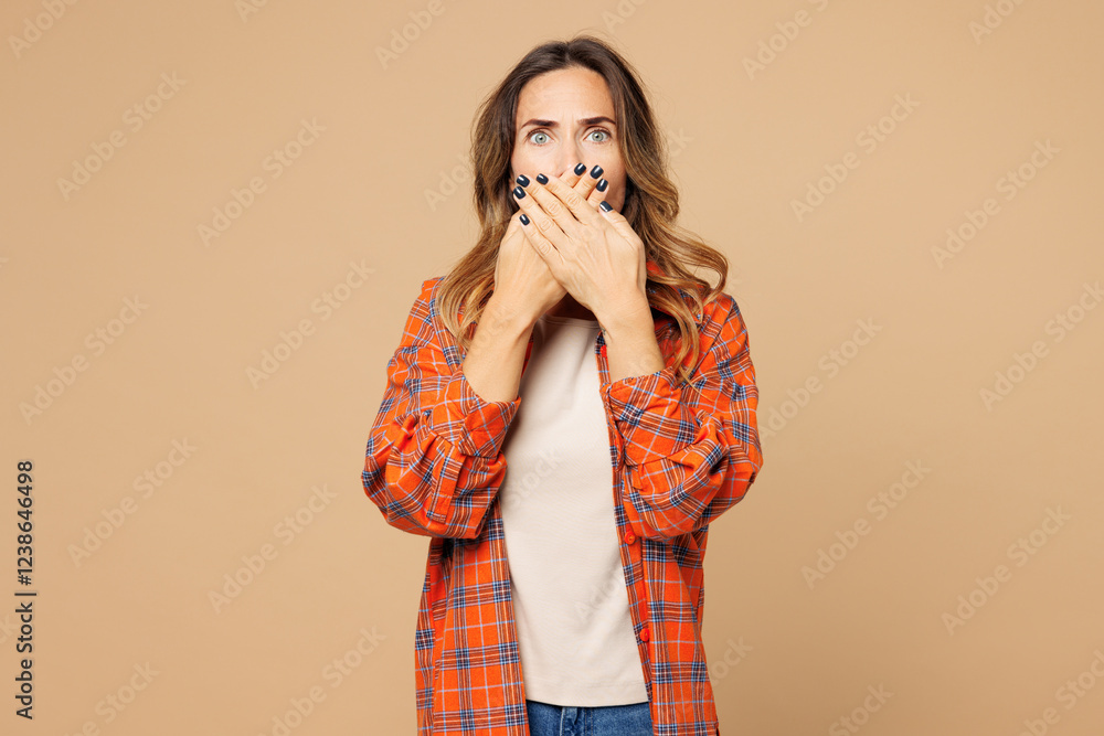 Φωτογραφία Young sad shocked surprised pop-eyed woman she wears orange shirt casual clothes cover mouth with hand look camera isolated on plain pastel light beige background studio portrait
