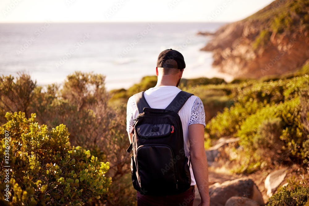 Fototapeta premium Walking, travel and back with man in nature for hiking, adventure and summer vacation. Trekking, tour guide and eco tourism with person outdoors for environment, wildlife reserve and backpacking