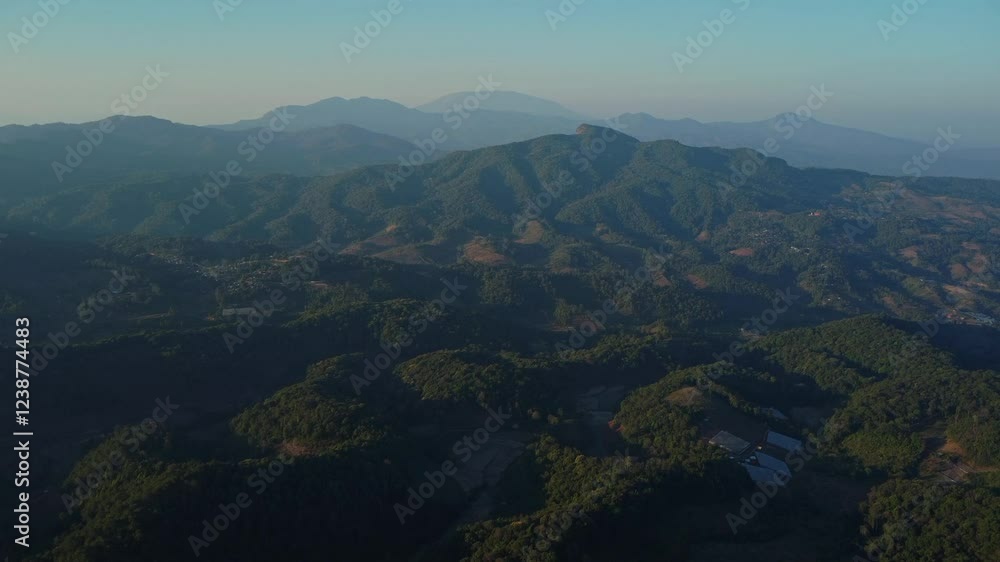 Beautiful sunrise on the mountain with fog in winter. The sun shines down on a serene mountain landscape covered with tropical trees in the early morning. Beautiful sunrise on the mountain with fog in winter. The sun shines down on a serene mountain landscape covered with tropical trees in the early morning.