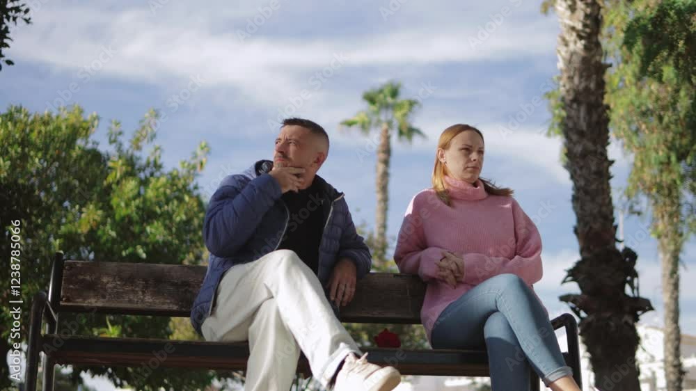 Heartbroken woman leaving single red rose on park bench, signaling painful relationship breakdown during valentine's romantic disappointment. Heartbroken woman leaving single red rose on park bench, signaling painful relationship breakdown during valentine's romantic disappointment.
