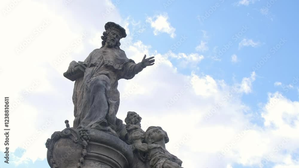 A beautifully crafted statue gracefully reaching out, framed by a stunning sky filled with fluffy clouds, Charles Bridge. Prague. Czech Republic A beautifully crafted statue gracefully reaching out, framed by a stunning sky filled with fluffy clouds, Charles Bridge. Prague. Czech Republic