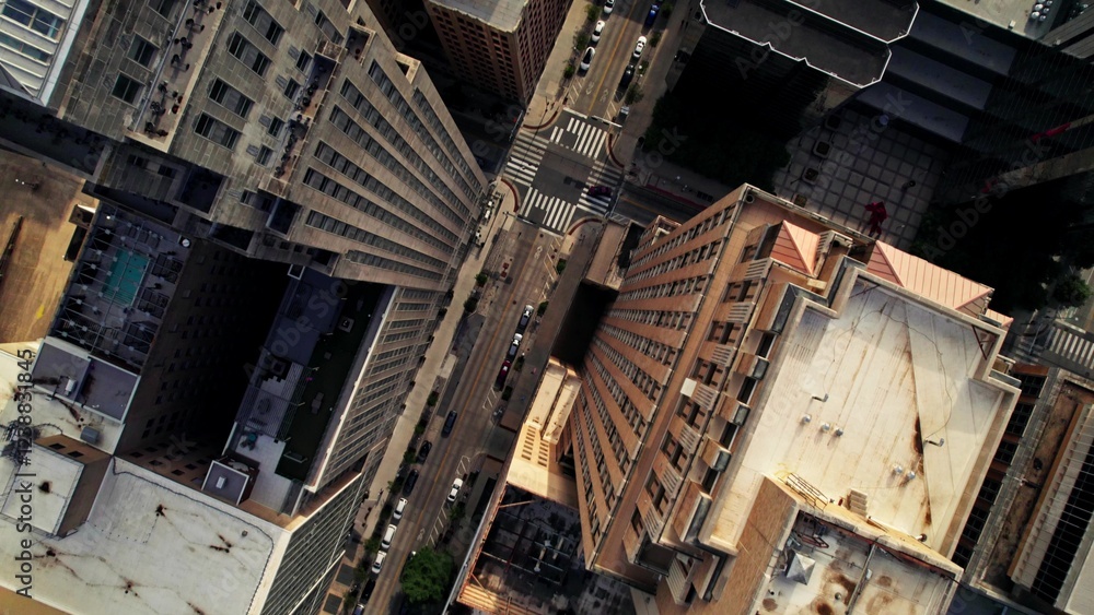 The drone flies over the roofs of the skyscrapers of an American city. Cars drive through the streets between the houses The drone flies over the roofs of the skyscrapers of an American city. Cars drive through the streets between the houses