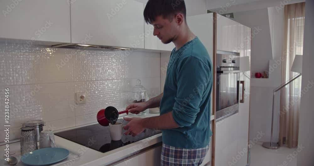 Young Man Pours Coffee in Modern Kitchen: Starting the Day with a Fresh Brew Young Man Pours Coffee in Modern Kitchen: Starting the Day with a Fresh Brew