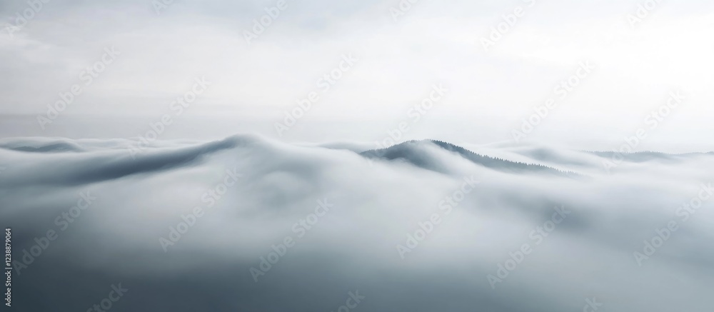 Obraz premium Foggy mountain peaks under a cloudy sky, abstract aerial landscape with soft light and smooth textures