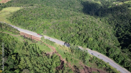 Veículos trafegando em uma estrada vicinal no interior de São Paulo, em uma estrada que corta a vegetação. photo