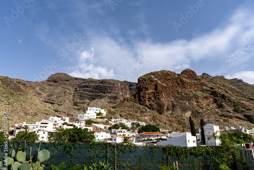 A mountain range with a small town in the agaete canary valley.