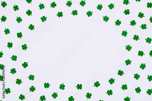 St Patrick's Day border, green quatrefoils, round border on the white wooden surface with free space for festive text photo