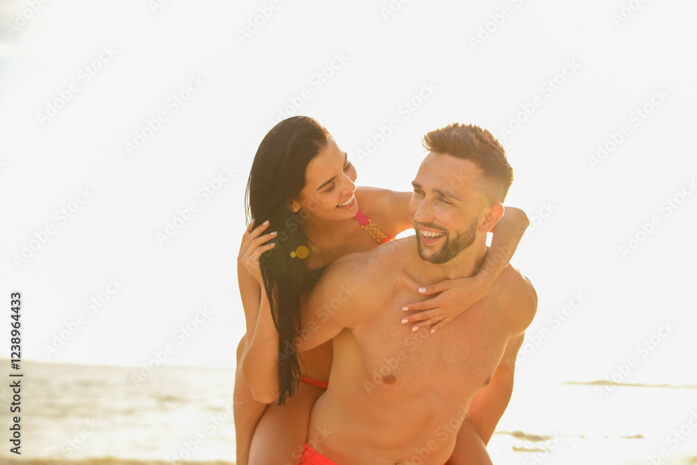 Happy young couple having fun on beach on sunny day Happy young couple having fun on beach on sunny day
