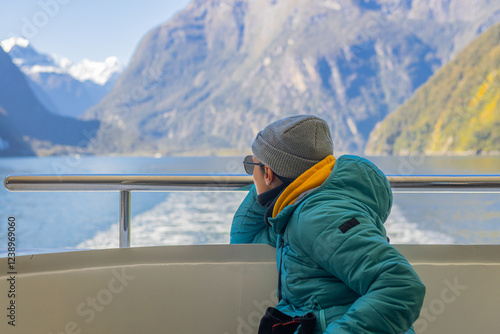 Tourist enjoying milford sound scenic boat tour in fiordland national park, new zealand