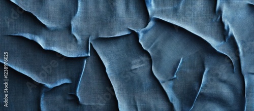 Wrinkled blue denim fabric texture background with natural creases and folds for design use Copy Space photo