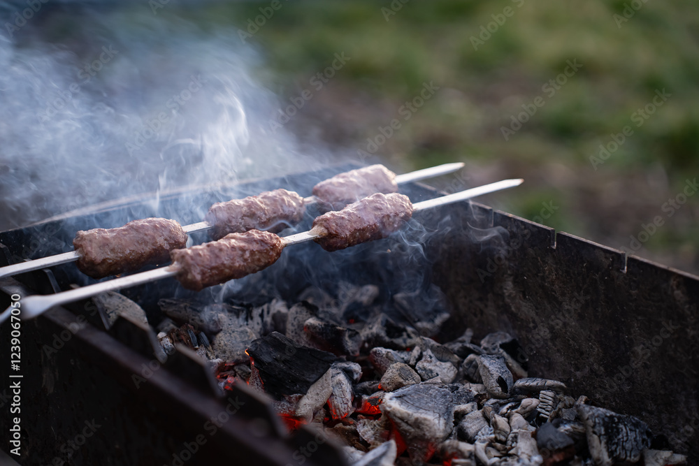 Food cooked outdoors on charcoal, hands in frame. Barbecue. Food cooked outdoors on charcoal, hands in frame. Barbecue.