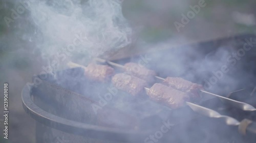 Food cooked outdoors on charcoal, hands in frame. Barbecue.