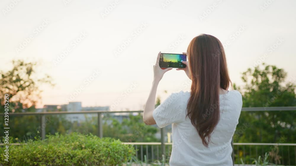 Woman Capturing Urban Nature Smartphone Photography in City Park Surrounded by Greenery and Skyline, Embracing Leisure and Connection with Outdoors Asian Digital technology lifestyle