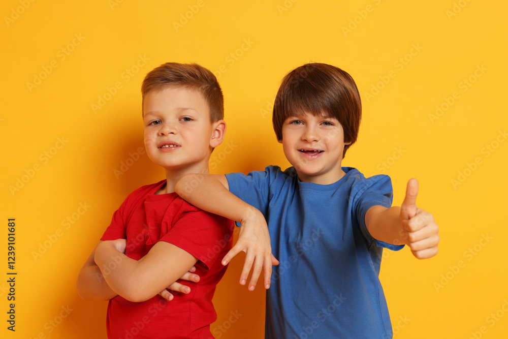 Portrait of cute brothers on orange background Portrait of cute brothers on orange background