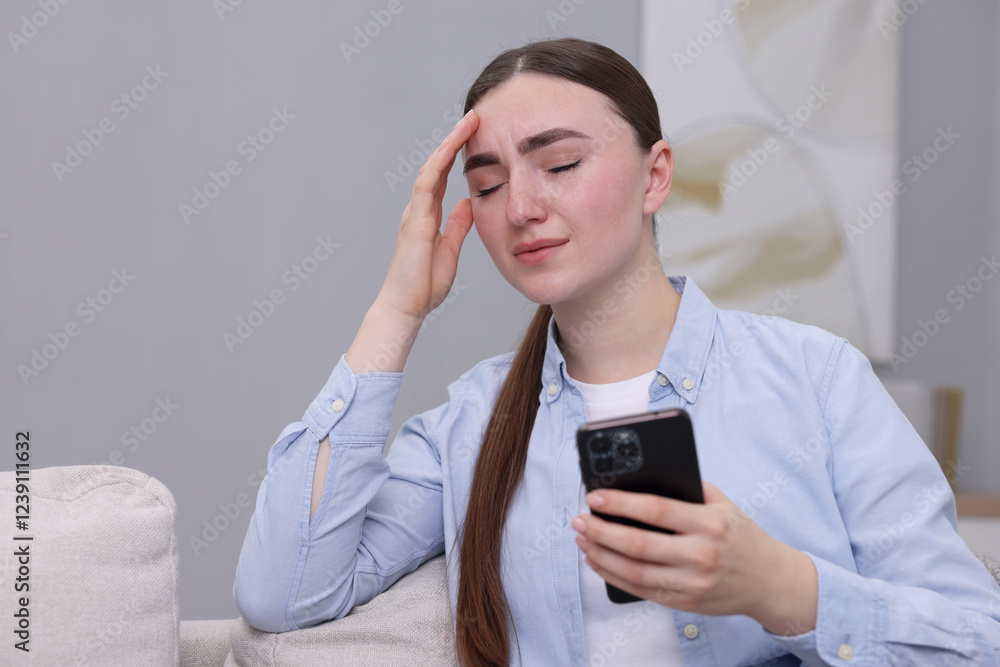 Depressed woman calling hotline for mental health help on sofa at home. Space for text Depressed woman calling hotline for mental health help on sofa at home. Space for text
