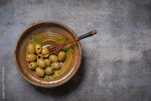 Obraz na płótnie Bowl of olives with a wooden spoon on a table w salonie