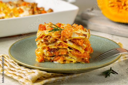 Plate with Pumpkin, cheese and sausage lasagna. Italian Baked pasta in casserole, homemade food.