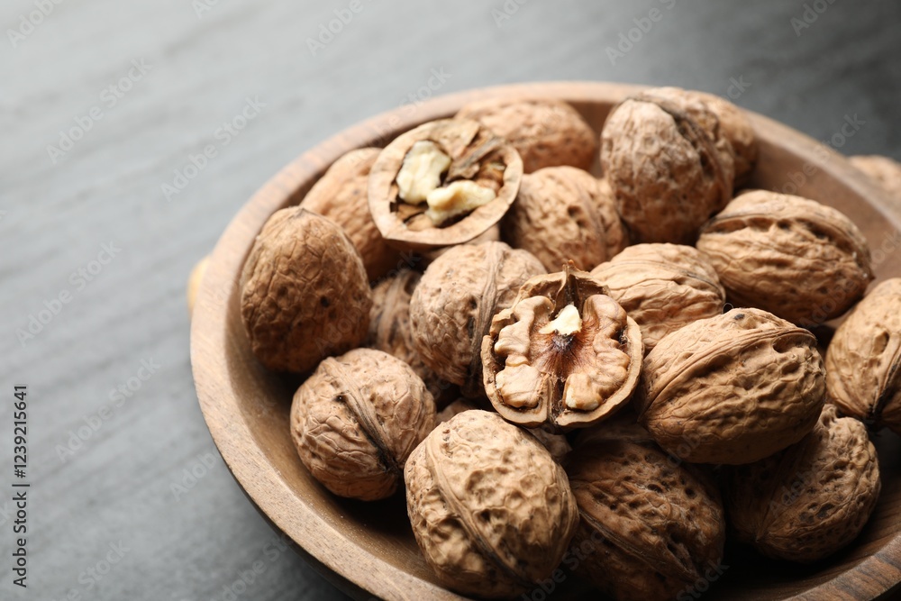 Fresh ripe walnuts in shells on black table, closeup Fresh ripe walnuts in shells on black table, closeup